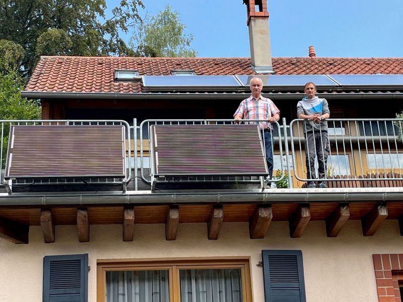 Das Foto zeigt zwei Personen auf einem Balkon mit installiertem Balkonkraftwerk